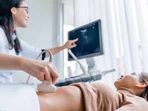 中年成年女医生使用超声扫描仪