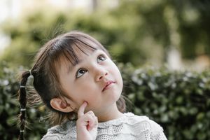 外面扎着小辫子的小女孩抬头思考着。