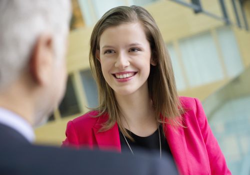 Business executives discussing in an office corridor.
