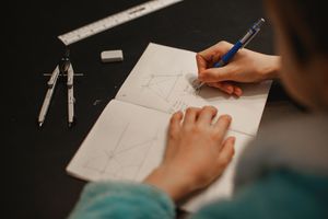 少年在笔记本上做数学题