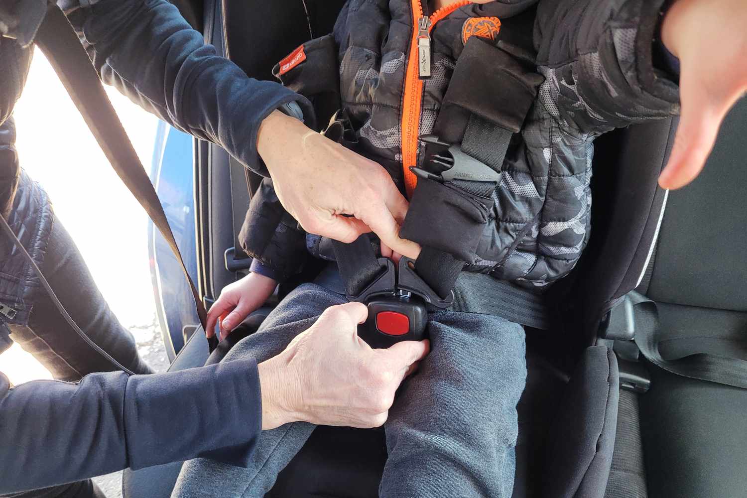 Person securing a child in the Diono Radian 3RXT