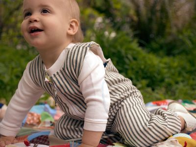 Baby crawling on a blanket outside