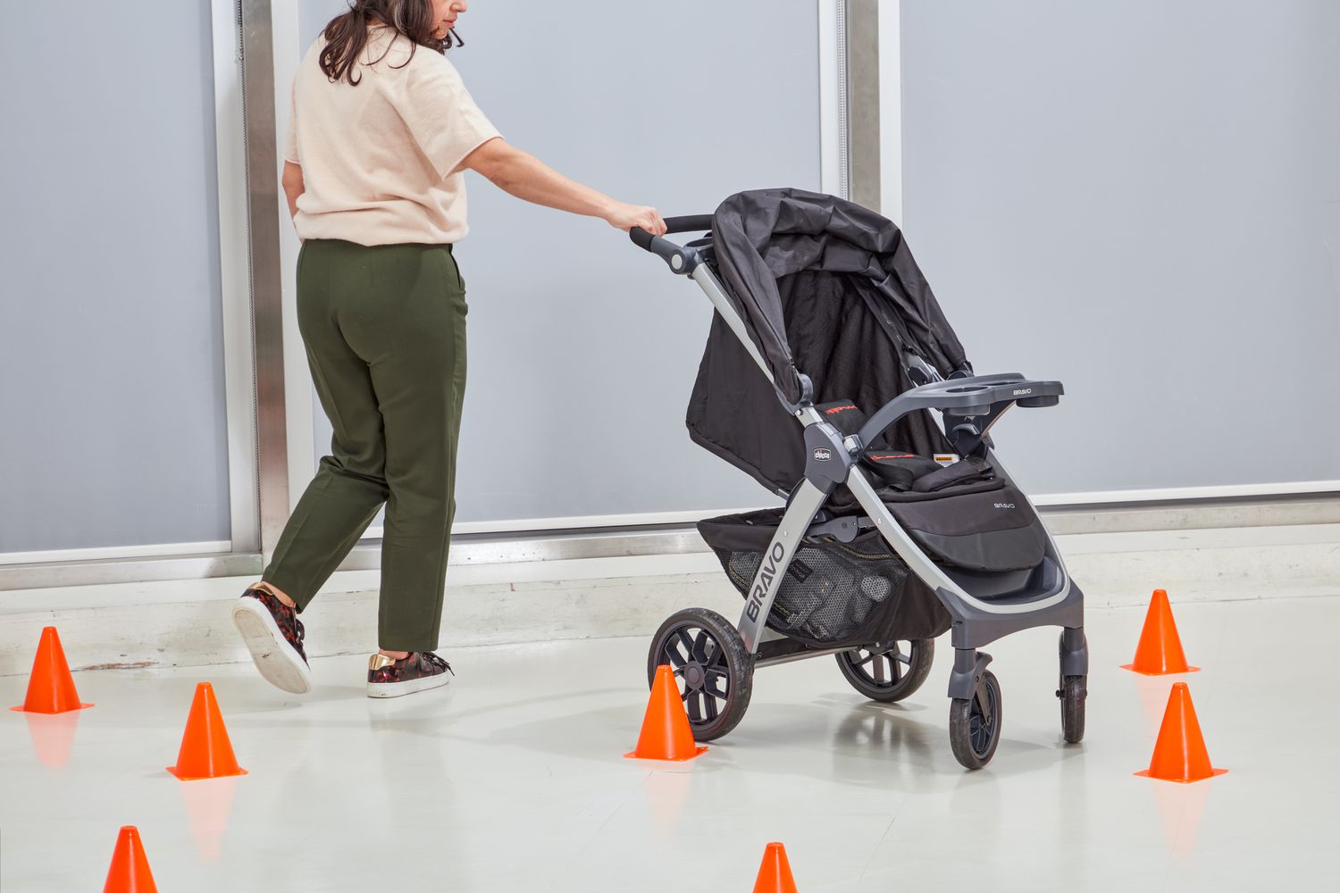 Person holding the handle of Chicco Bravo Trio Travel System