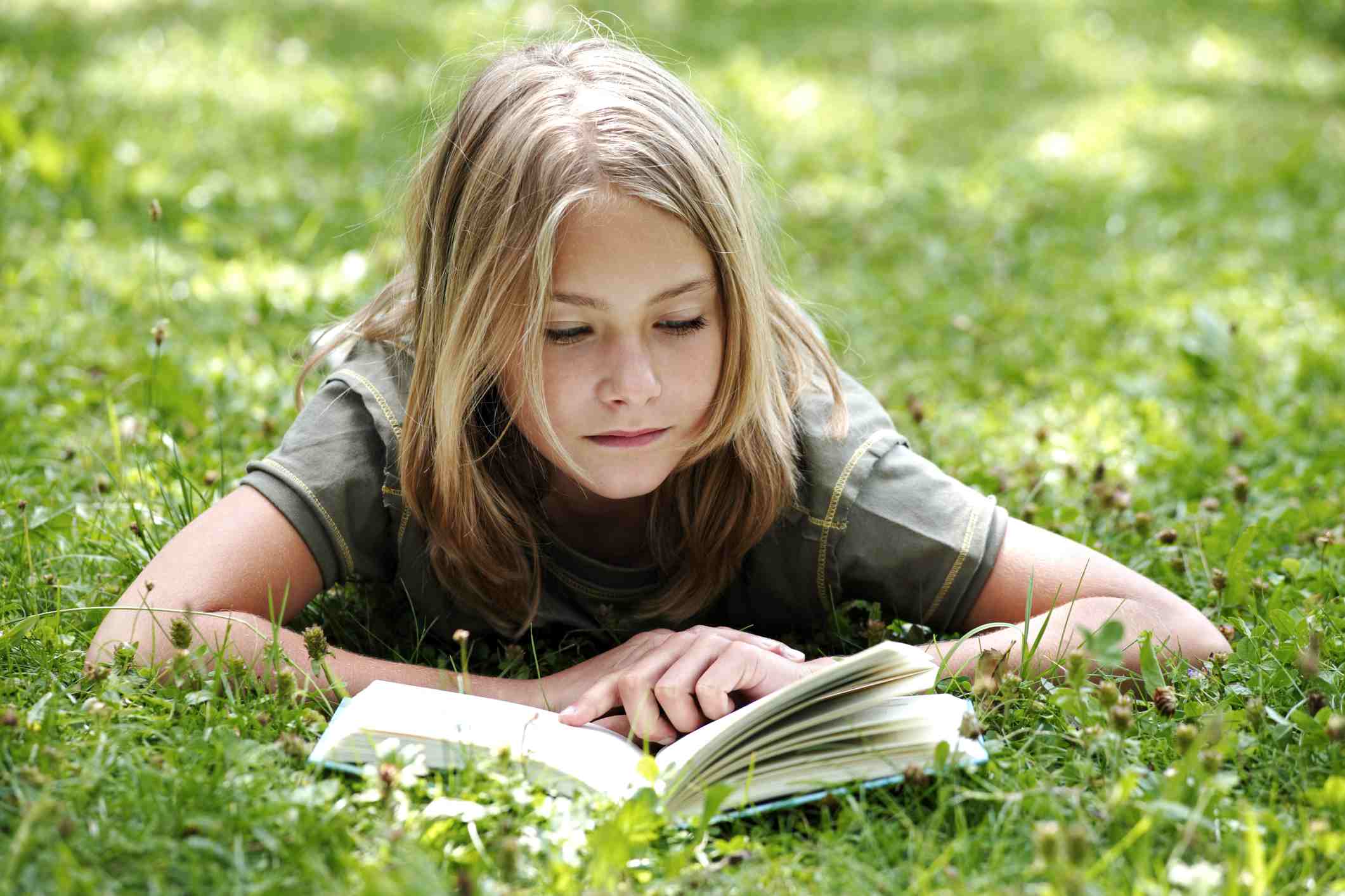 一个小女孩在草地上看书