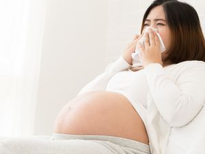 孕妇用纸巾捂着鼻子