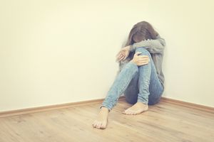 不快乐的女孩坐在角落里