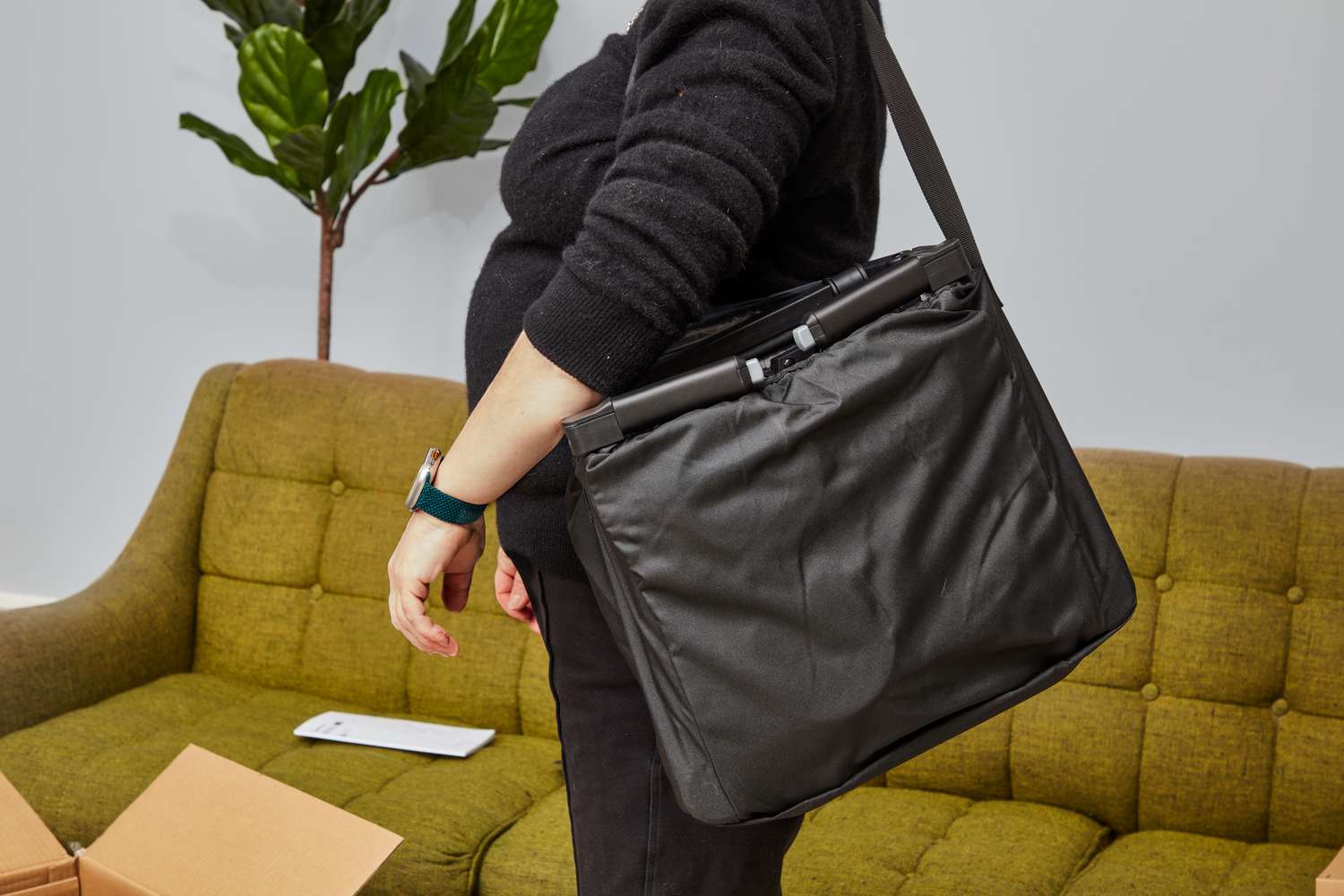 Person carrying folded Munchkin Sparrow inside a bag