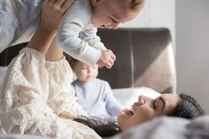 白人母亲躺在床上抱着婴儿的儿子