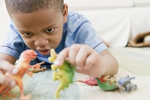 Boy playing with dinosaur figurines
