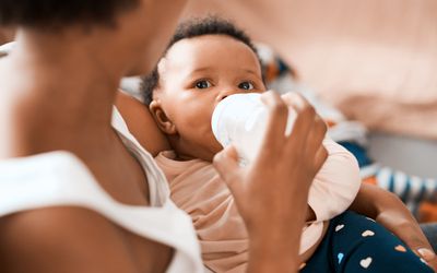 Mother bottle-feeding her infant daughter