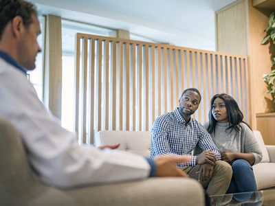 A couple consults with a doctor about a fertility assessment.