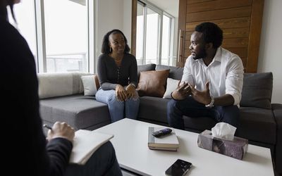 Couple on sofa talking during marriage counseling session