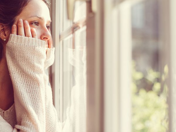 穿白毛衣的女人望着窗外。
