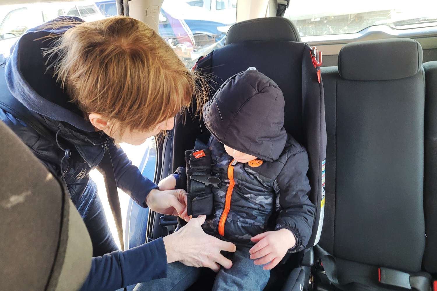Person securing a child in the Diono Radian 3RXT