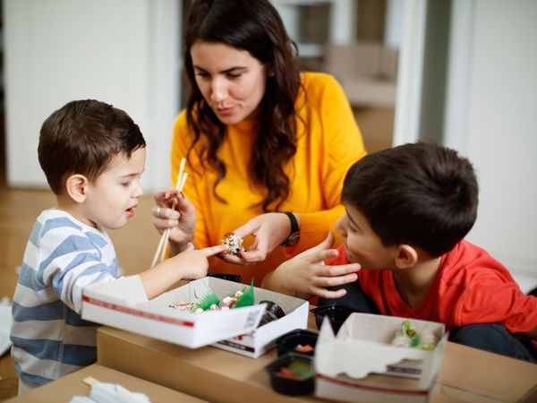 Mom and toddler boys eating sushi