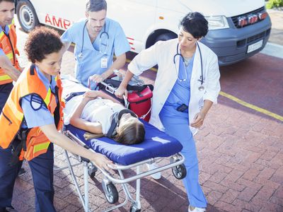 Doctor, nurse and paramedics wheeling patient on stretcher