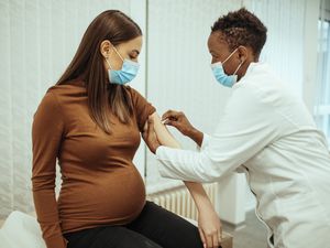 孕妇准备通过手臂消毒接种疫苗。