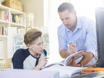 A father helps his son with homework.