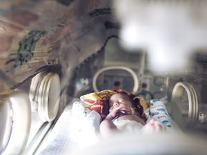 在婴儿床上，她的儿子在睡觉前