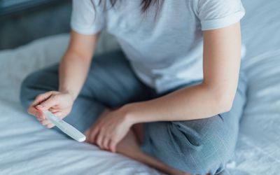 一个年轻女子拿着验孕棒的特写镜头。华体会体育官方人口