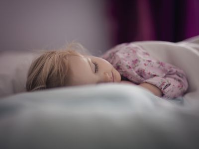 Toddler girl (2-3) sleeping on bed