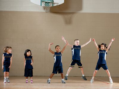 kids in gym doing jumping jacks
