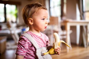 little girl eating a banana