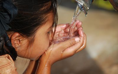 一个正在喝水的女孩被倒进了她的手里