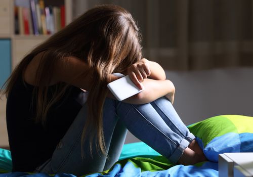心烦意乱的少女手里拿着手机