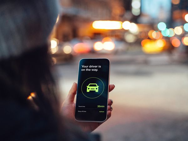 Woman requesting an Uber ride on an app on her smartphone.
