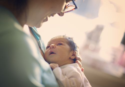 Mom smiling at newborn