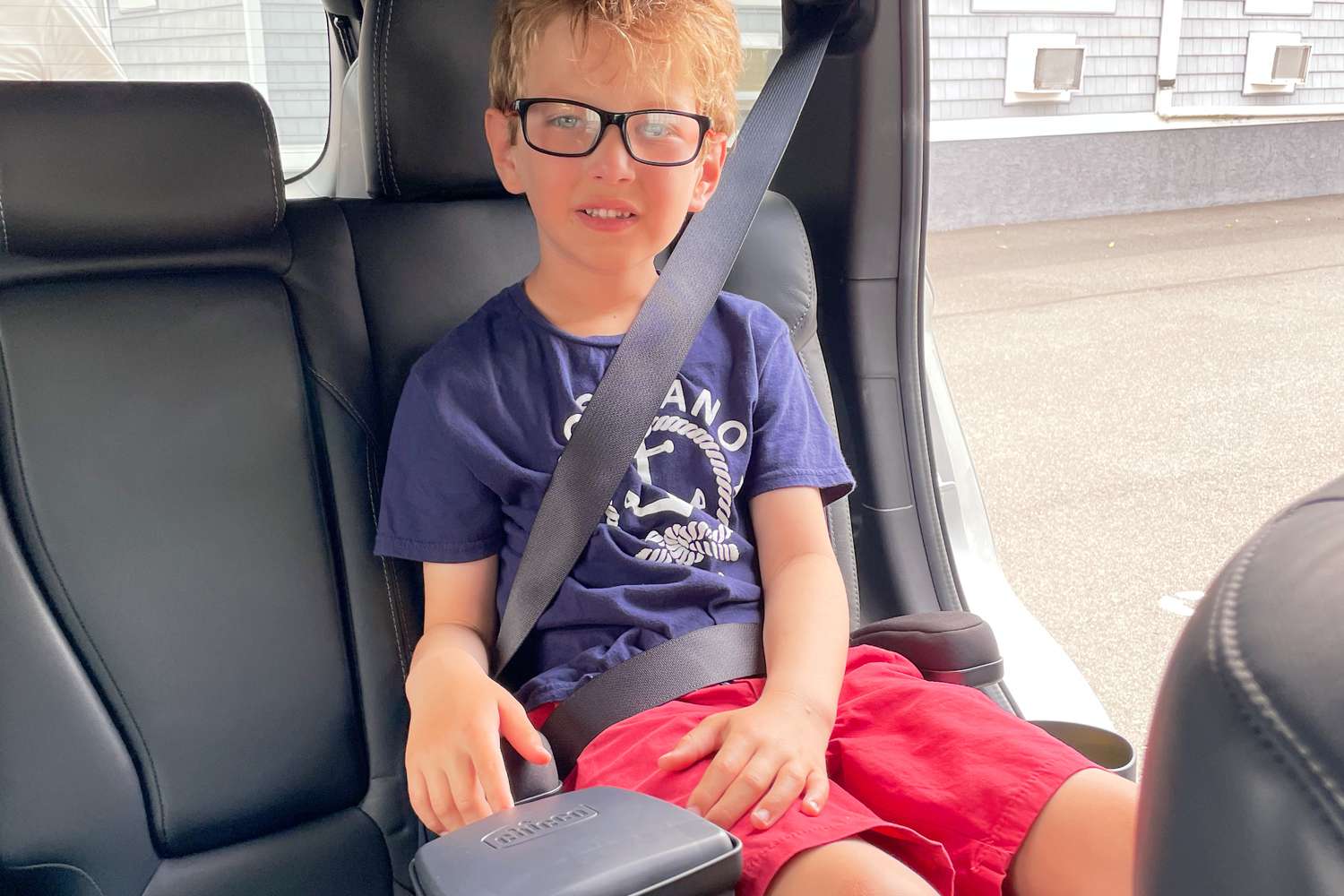 A child sitting in the Chicco KidFit Zip Air Plus 2-in-1 Belt-Positioning Booster Car Seat