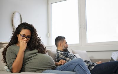 一个抑郁的孕妇和她的伴侣在沙发上