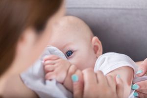 可爱的蓝眼睛宝宝在哺乳时看着妈妈