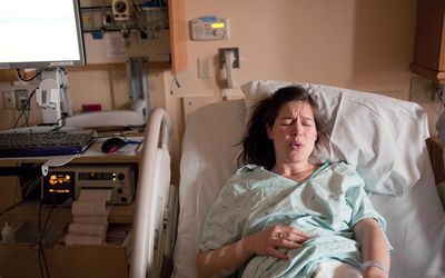 在医院病床上分娩的孕妇