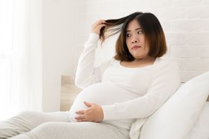一个孕妇把她的头发从头上扯下来。
