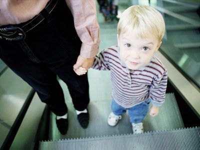 YOUNG BOY WITH MOTHER ON ESCALATOR