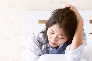 心烦意乱的女人把头抱在床上