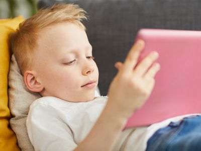 young boy on couch with iPad