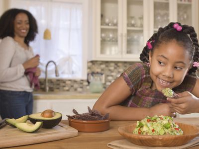 A child eating chips with guacamole.