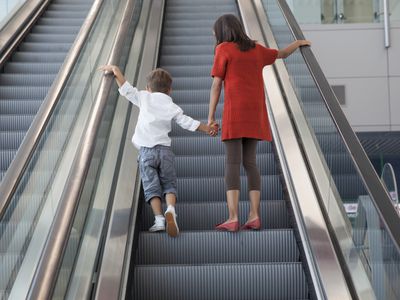 Boy and girl standing on escalator.