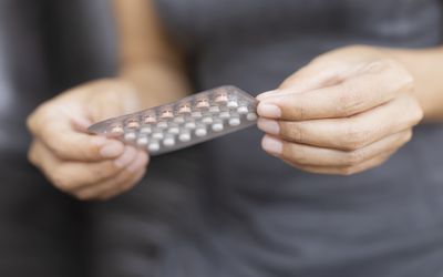 女人拿着一袋避孕药