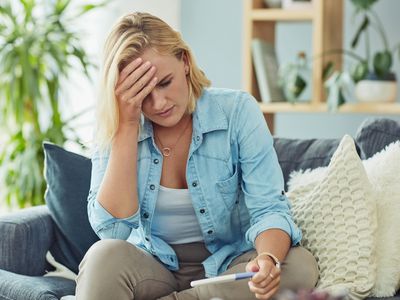 Young woman taking a pregnancy test at home and looking worried