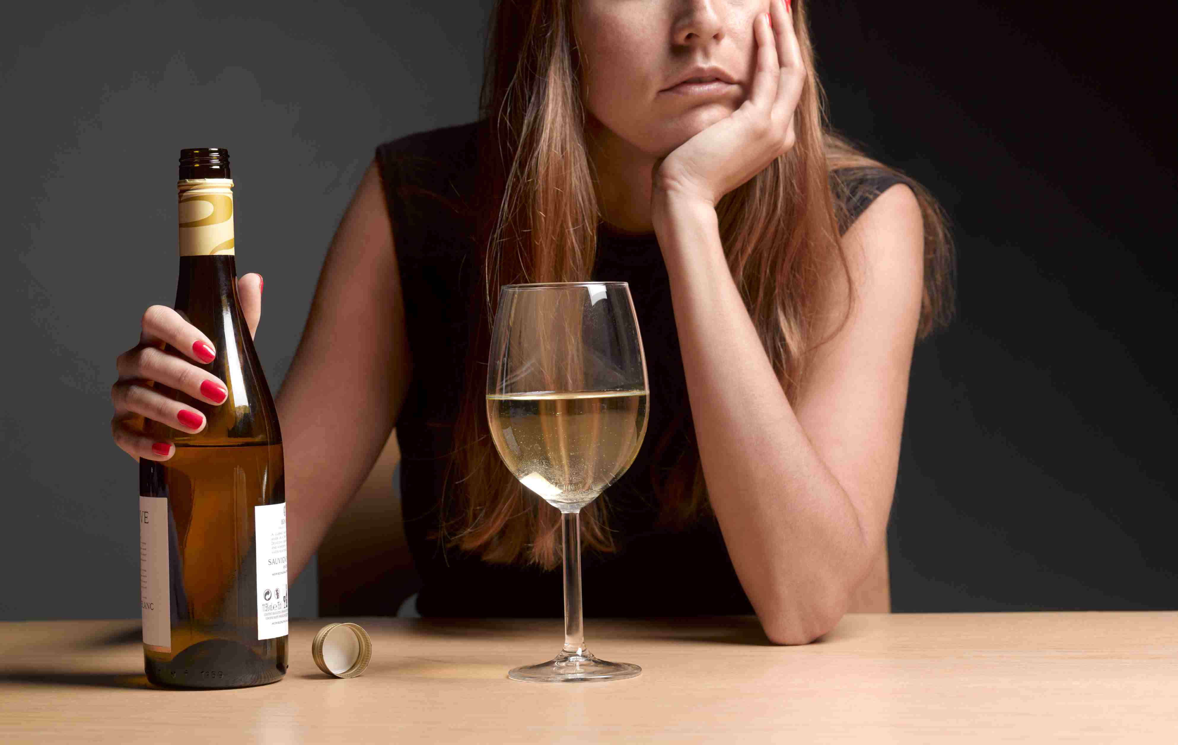 拿着一瓶酒的女人看起来很沮丧