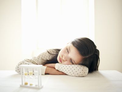 sad girl at table with timer