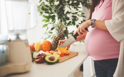Pregnant woman cutting vegetables