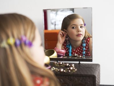 girl trying on jewelry in mirror