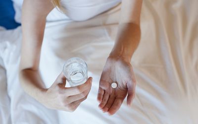 手里拿着药和水的女人