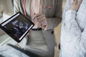 doctor showing fetus on ultrasound on tablet