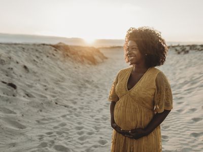 Pregnant Black woman holding her baby bump